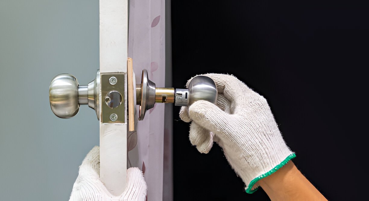 Locksmith fitting a mortice deadlock below an existing nightlatch in North London