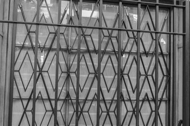 Retractable concertina security grille fitted to a shopfront in North London
